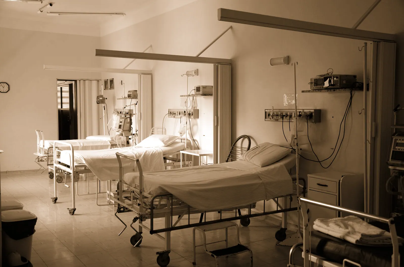 Warm clinical treatment room with a treatment bed, wood cabinetry, and soft daylight